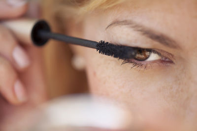 Close-up of woman applying mascara