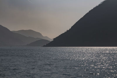 Scenic view of sea and mountains against sky