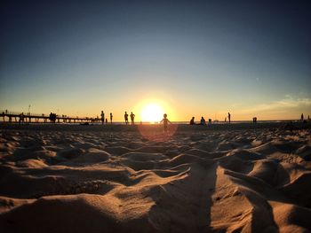 Boy standing at beach during sunset