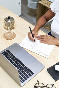 Businesswoman writing in note pad working at home office