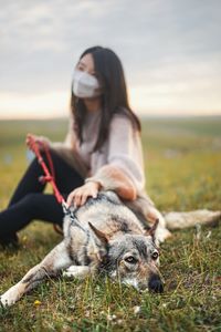 Portrait of woman with dog on field