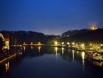 Illuminated bridge over river at night