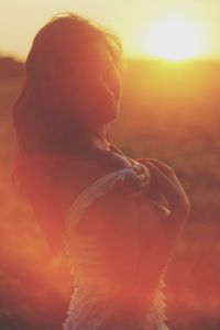 Portrait of woman removing top while standing on field