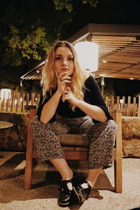 Portrait of woman sitting outdoors at night