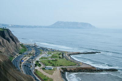 Aerial view of road by sea against sky