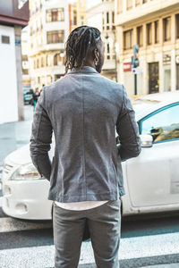 Rear view of man standing on street in city