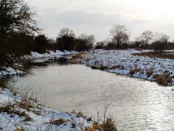 Scenic view of river against sky during winter