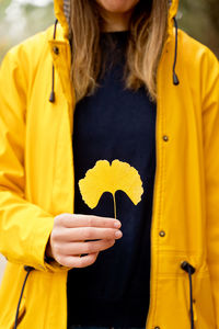 Midsection of woman holding heart shape leaf