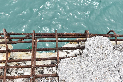 High angle view of metal railing against sea