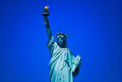 Low angle view of statue against blue sky