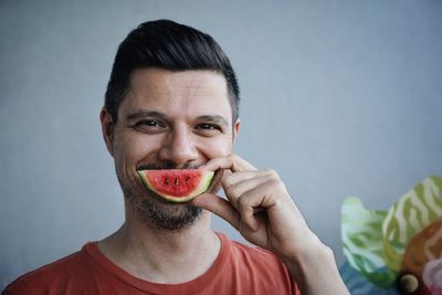 Portrait of mid adult man eating watermelon