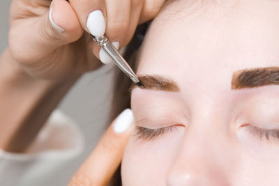 Eyebrow tinting. close-up of a master applying eyebrow dye with a brush. cosmetic procedures