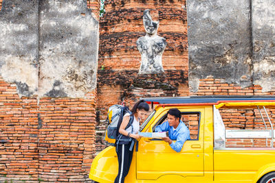 Woman showing map to man sitting in van