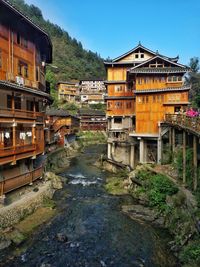 Bridge over river amidst buildings against sky