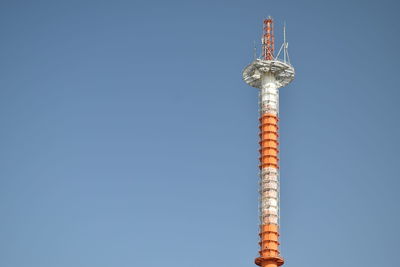 Low angle view of communications tower against clear blue sky