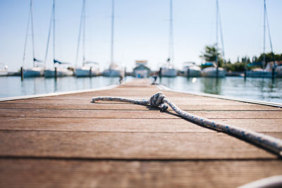 Close-up of sailboat on pier against sky