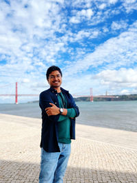 Portrait of young man standing at historic bridge of portugal 