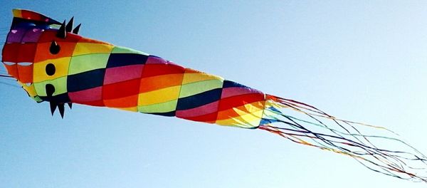 Low angle view of colorful balloons against clear blue sky