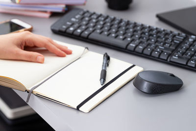 Midsection of person using smart phone on table