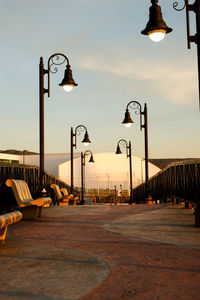 Street lights against sky at sunset