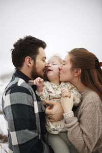 Parents embracing and kissing disabled child