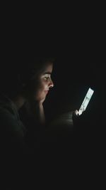 Woman using smart phone in the dark
