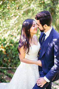 Newlywed couple romancing while standing at park