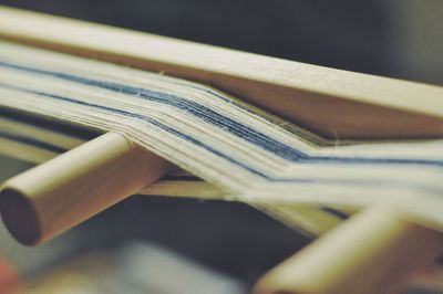 Close-up of thread on wood at textile factory