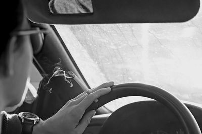 Close-up of man smoking cigarette while driving car