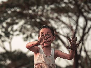 Happy little boy play mud.