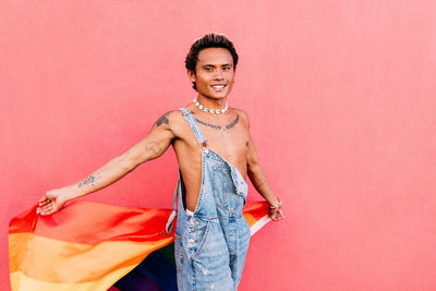 Smiling gay man holding rainbow flag