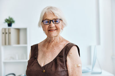 Portrait of woman smiling while sitting at hospital