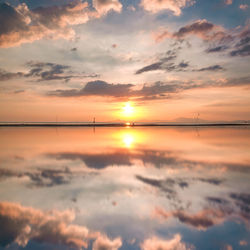 Scenic view of sea against dramatic sky during sunset