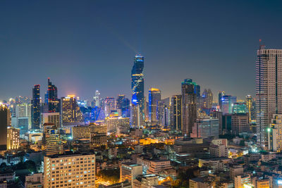 Illuminated buildings in city against sky