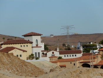 Buildings in city against clear sky