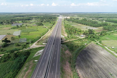 High angle view of road amidst field against sky