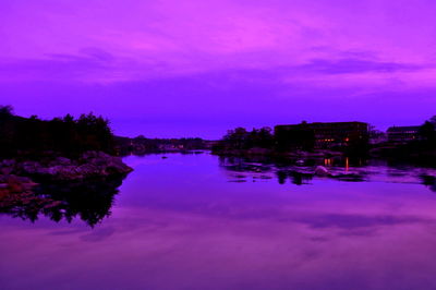 Reflection of trees in water at sunset