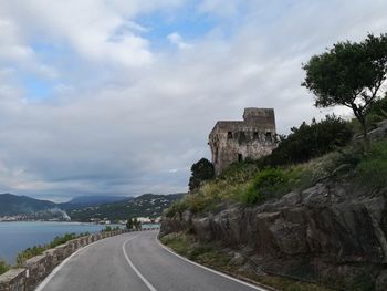 Road by mountain against sky