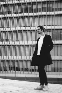 Full length of woman standing against brick wall