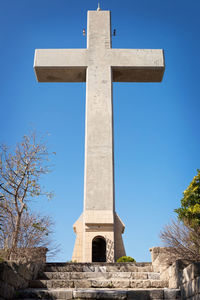 Low angle view of cross against clear blue sky