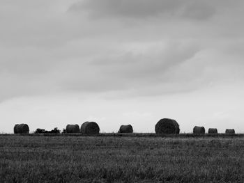 Hay bales on field against sky