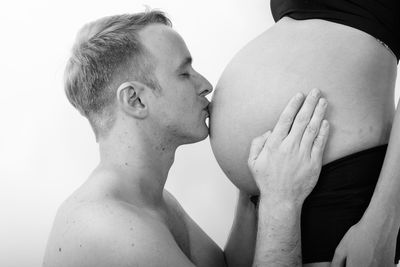 Man kissing pregnant belly of woman