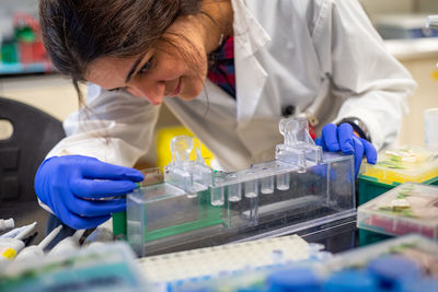 Close-up of female scientist with test tubes working in laboratory