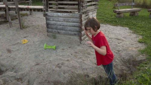 Rear view of boy standing outdoors