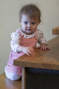 Portrait of cute baby girl sitting at home