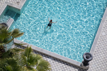 HIGH ANGLE VIEW OF WOMAN IN SWIMMING POOL