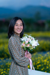 Portrait of a smiling young woman against blue sea