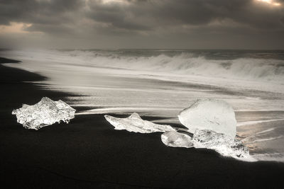 Captivating ice formations on the black sands of diamond beach during a cloudy day