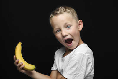 Portrait of boy against black background