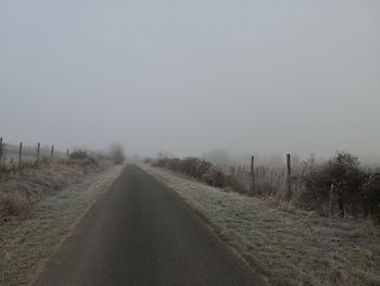 Empty road along countryside landscape